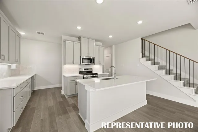 a kitchen with a sink stove and cabinets
