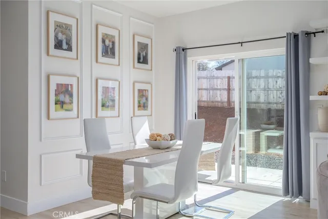 a kitchen with stainless steel appliances granite countertop a stove top oven a refrigerator a sink and chairs