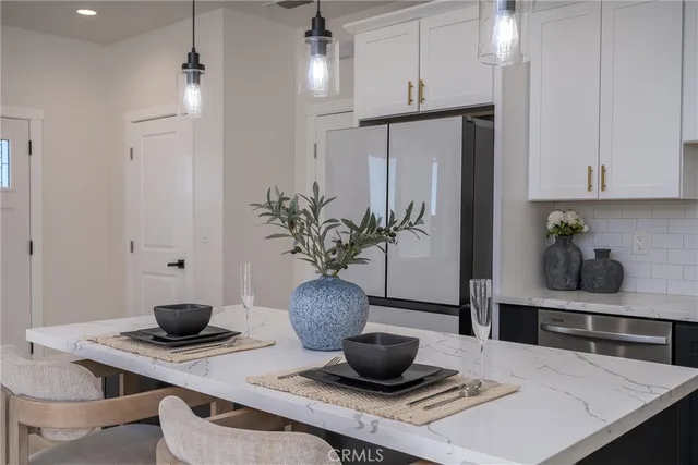 a kitchen with a table a clock and cabinets