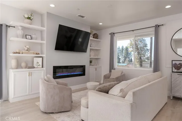 a living room with furniture and a view of kitchen