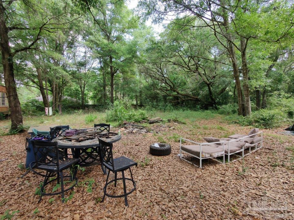 a view of a backyard with lawn chairs and a fire pit