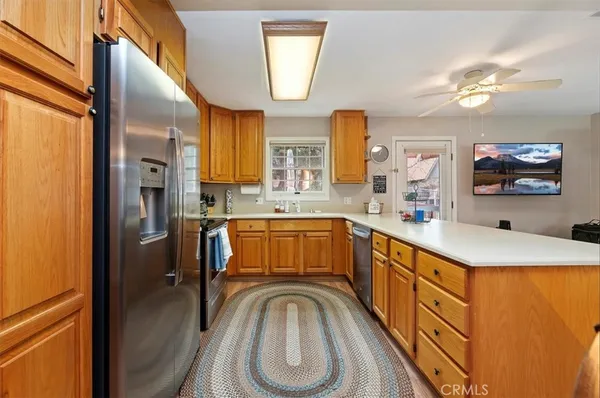 a kitchen with stainless steel appliances granite countertop a sink refrigerator and cabinets