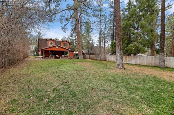 a view of a yard with large trees and a barn