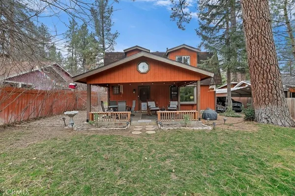 a view of a house with backyard and sitting area
