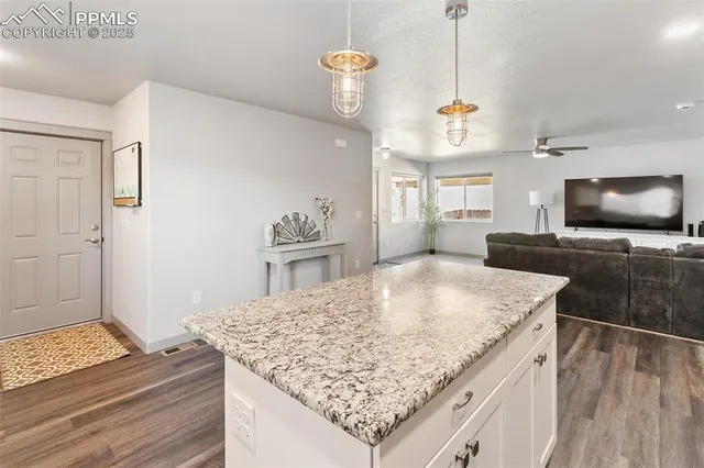 a kitchen with kitchen island granite countertop a sink stove and refrigerator