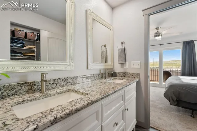 a en suite bathroom with a granite countertop sink and a mirror