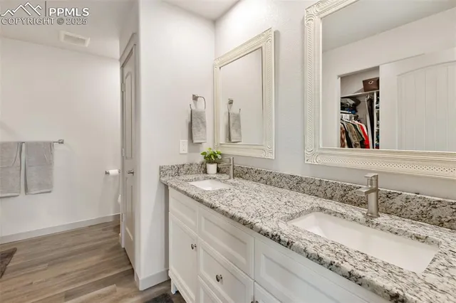 a bathroom with a granite countertop sink and a mirror