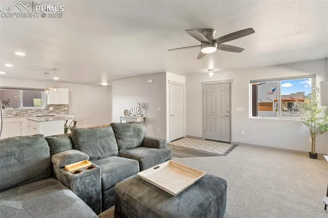 a living room with furniture and kitchen view