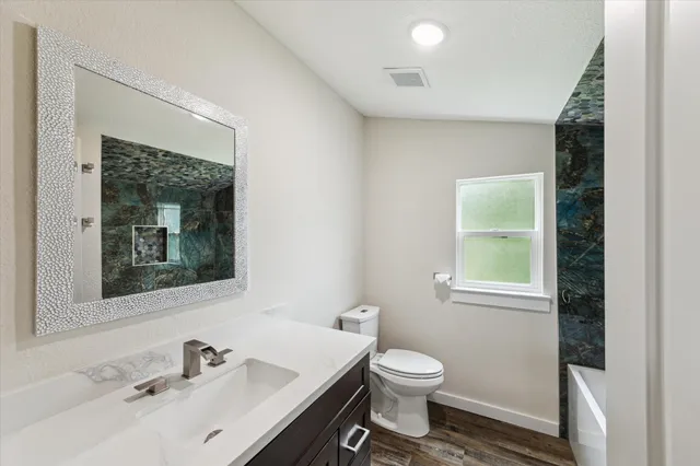 a bathroom with a toilet sink and mirror