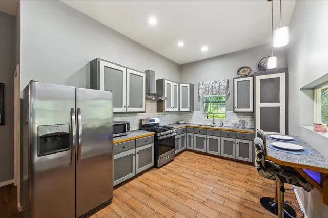 a kitchen with stainless steel appliances a sink stove and cabinets