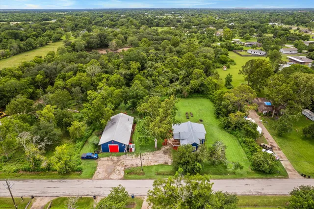 an aerial view of residential houses with outdoor space and trees