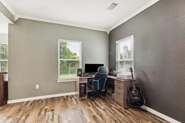 a view of a workspace with wooden floor and a window
