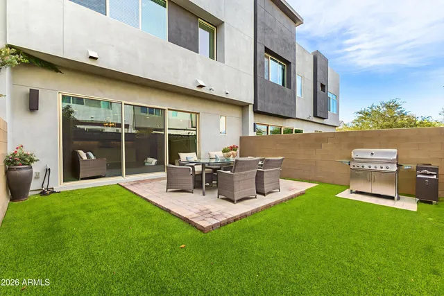 a view of a chair and table in the back yard of the building
