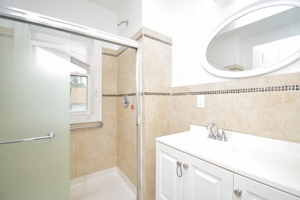 141 Oak Street Springfield, MA 01109 - Photo 24 of 40 a bathroom with a sink a mirror and a shower