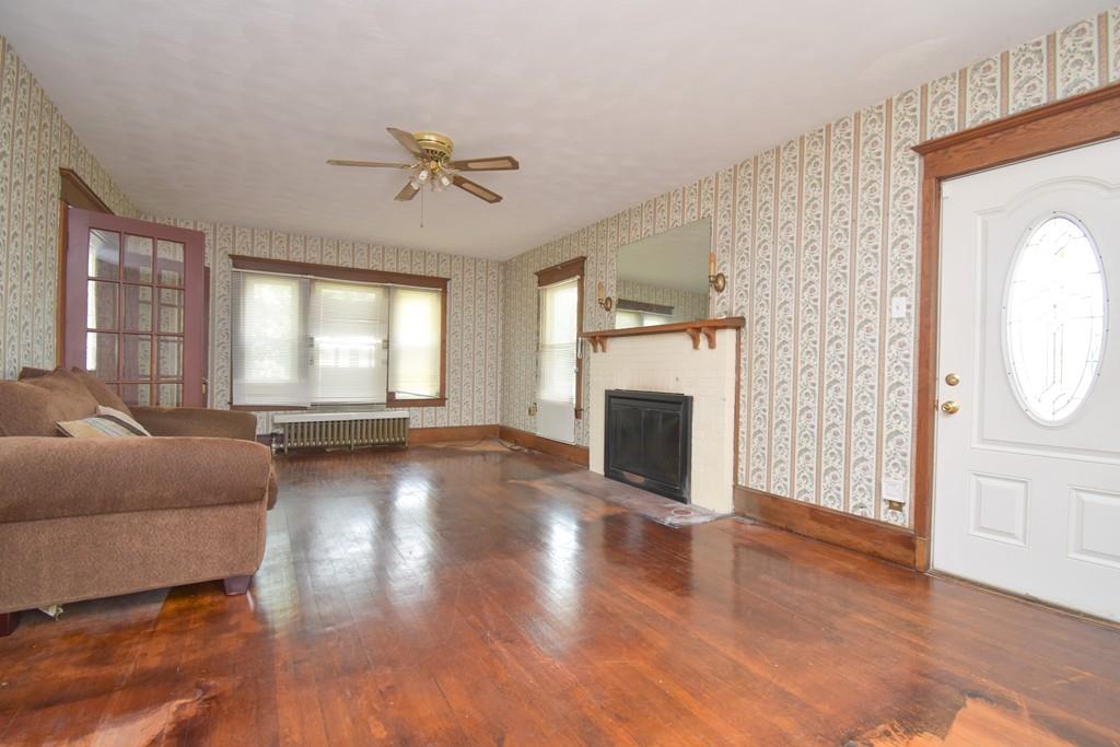 141 Oak Street Springfield, MA 01109 - Photo 3 of 40 a view of a livingroom with a fireplace a ceiling fan and windows