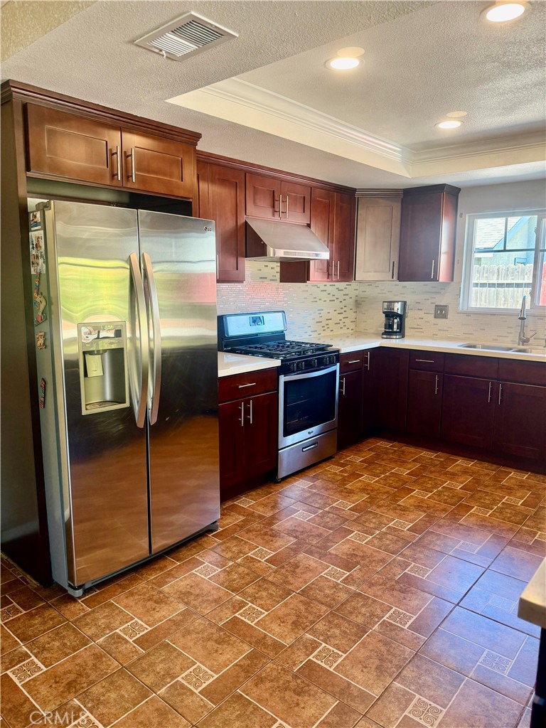 5982 Harrison Street Chino, CA 91710 - Photo 21 of 43 a kitchen with stainless steel appliances granite countertop a sink stove and refrigerator