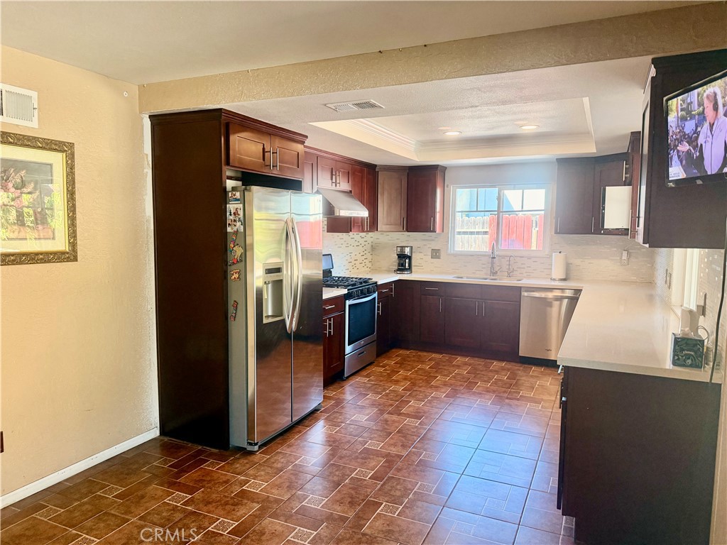 5982 Harrison Street Chino, CA 91710 - Photo 22 of 43 a kitchen with stainless steel appliances granite countertop a refrigerator and a sink