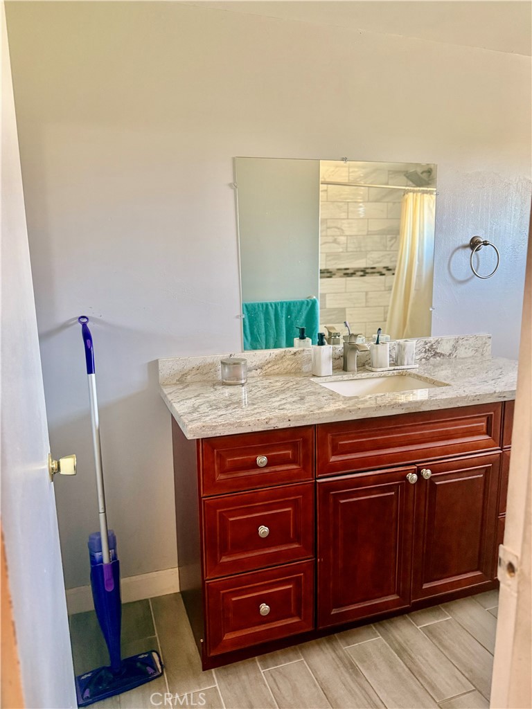 5982 Harrison Street Chino, CA 91710 - Photo 32 of 43 a bathroom with a granite countertop sink and a mirror