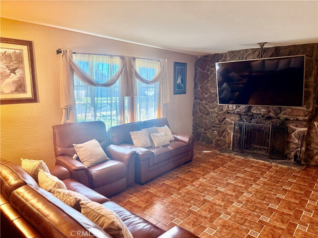 5982 Harrison Street Chino, CA 91710 - Photo 35 of 43 a living room with furniture a flat screen tv and a fireplace