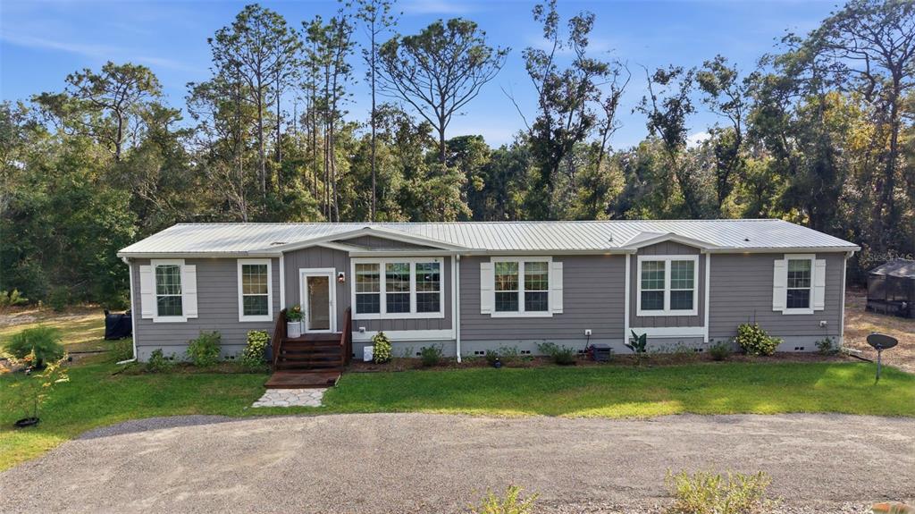 6170 La Pine Road Brooksville, FL 34602 - Photo 51 of 63 a front view of a house with a garden