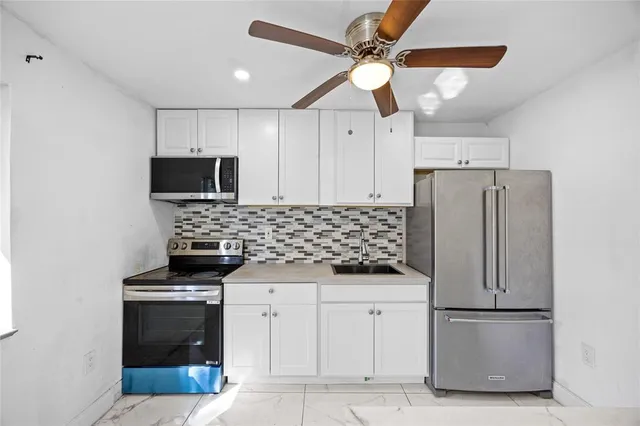 a kitchen with stainless steel appliances a refrigerator a stove a microwave and cabinets