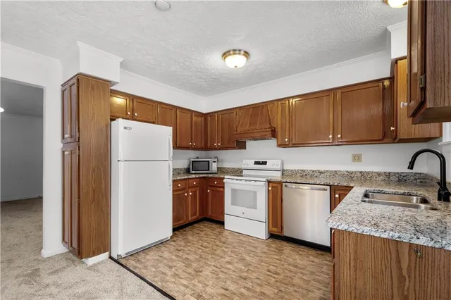 a kitchen with stainless steel appliances granite countertop a refrigerator stove a sink and dishwasher