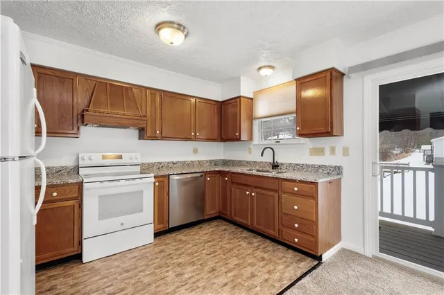a kitchen with stainless steel appliances granite countertop a sink stove and cabinets