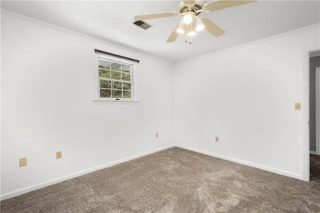 an empty room with a window and a ceiling fan