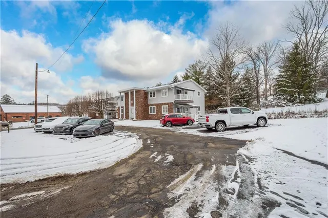 a view of a city street with a car parked on the roadside