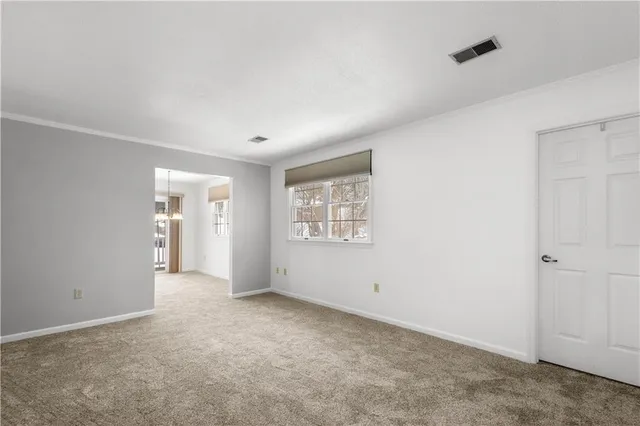 a view of an empty room with closet and a window