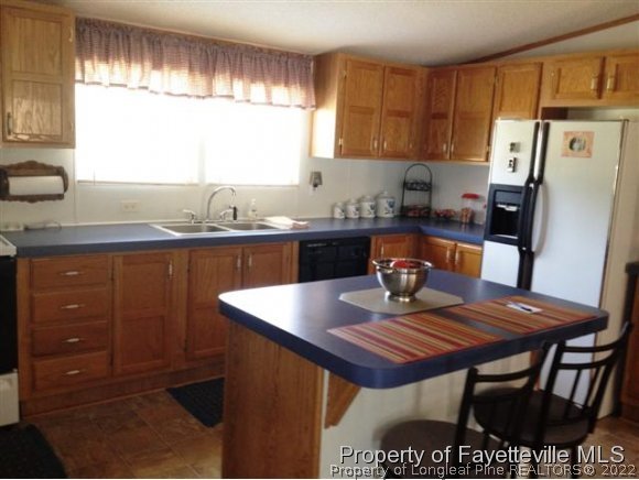 2400 Hayfield Road Wade, NC 28395 - Photo 2 of 15 a kitchen with a table chairs and a refrigerator