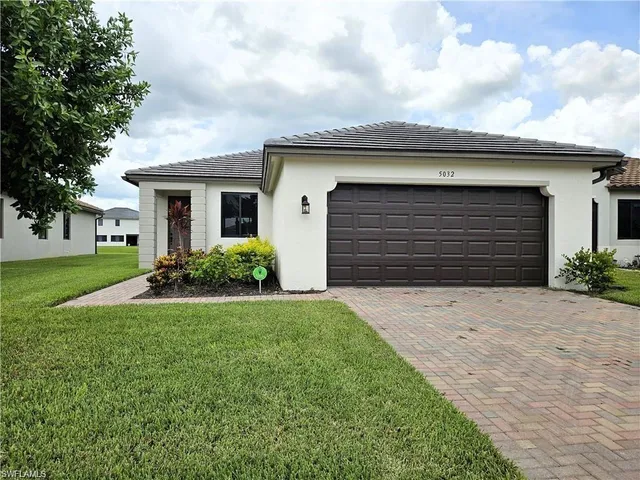 a front view of a house with a yard and garage
