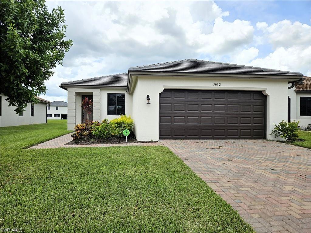 a front view of a house with a yard and garage