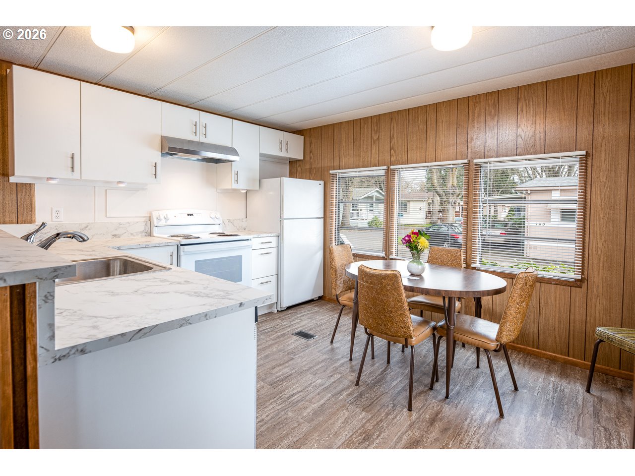 1475 Green Acres Road, Unit 172 Eugene, OR 97408 - Photo 9 of 20 a kitchen with stainless steel appliances kitchen island granite countertop a table chairs sink refrigerator and cabinets
