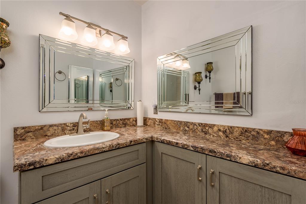 1901 Lennox Road East, Unit 1901 Palm Harbor, FL 34683 - Photo 14 of 25 a bathroom with a granite countertop sink two large mirror and a