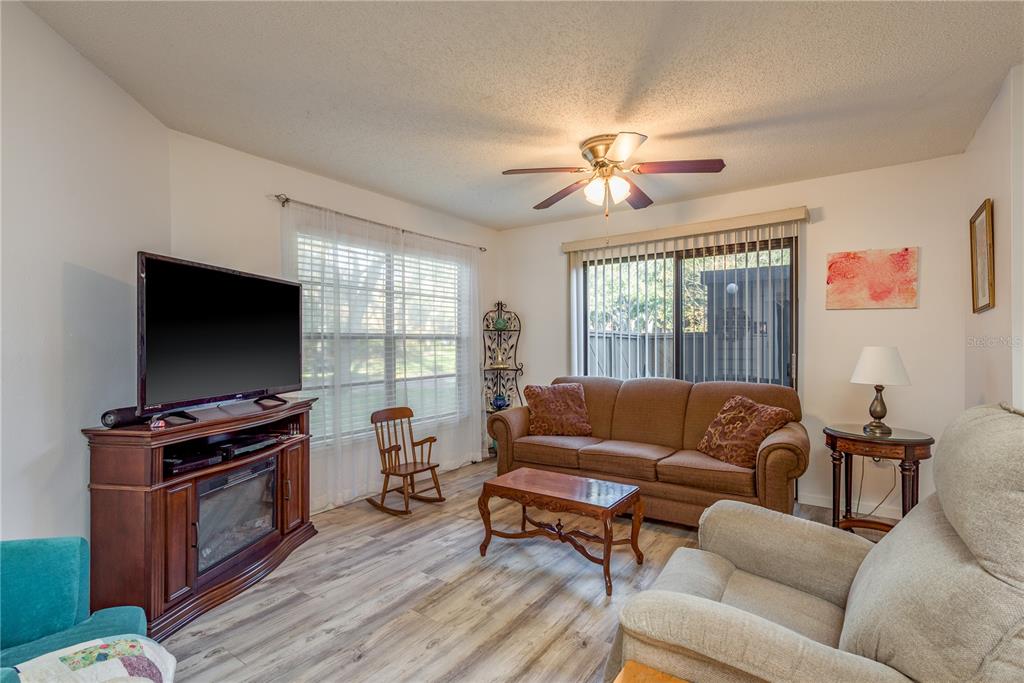 1901 Lennox Road East, Unit 1901 Palm Harbor, FL 34683 - Photo 4 of 25 a living room with furniture a flat screen tv and wooden floor