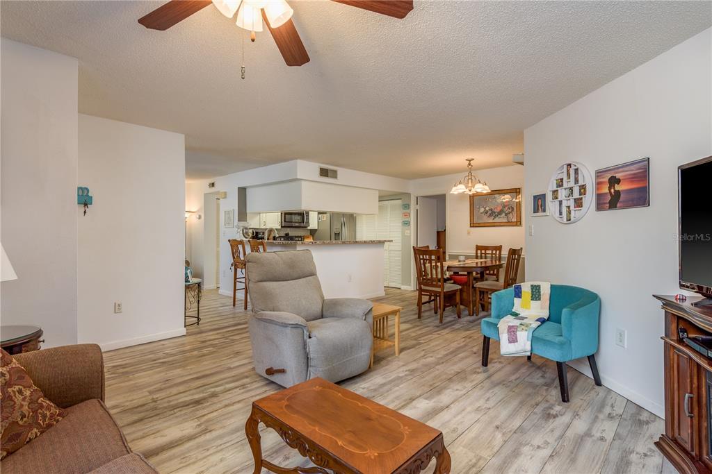 1901 Lennox Road East, Unit 1901 Palm Harbor, FL 34683 - Photo 5 of 25 a living room with furniture and a dining table with wooden floor
