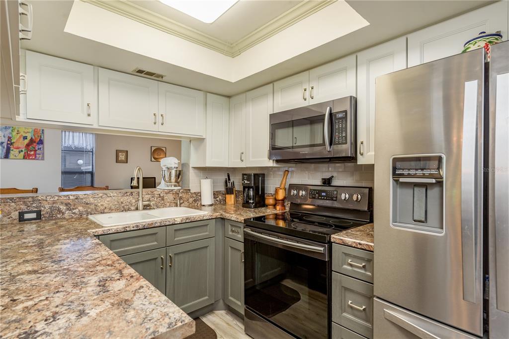 1901 Lennox Road East, Unit 1901 Palm Harbor, FL 34683 - Photo 9 of 25 a kitchen with a sink stove and refrigerator