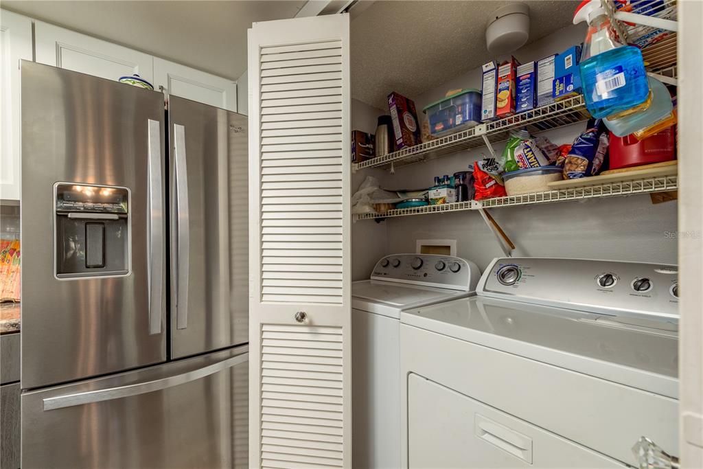 1901 Lennox Road East, Unit 1901 Palm Harbor, FL 34683 - Photo 10 of 25 a kitchen with a refrigerator and a shelf
