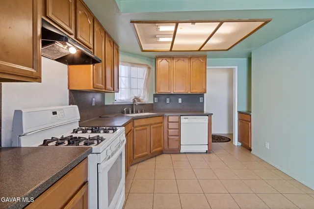 a kitchen with a sink a stove cabinets and a window