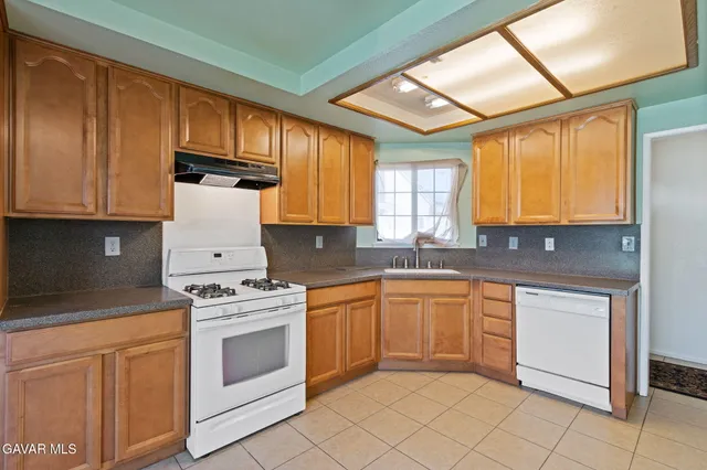 a kitchen with granite countertop cabinets stainless steel appliances and a sink