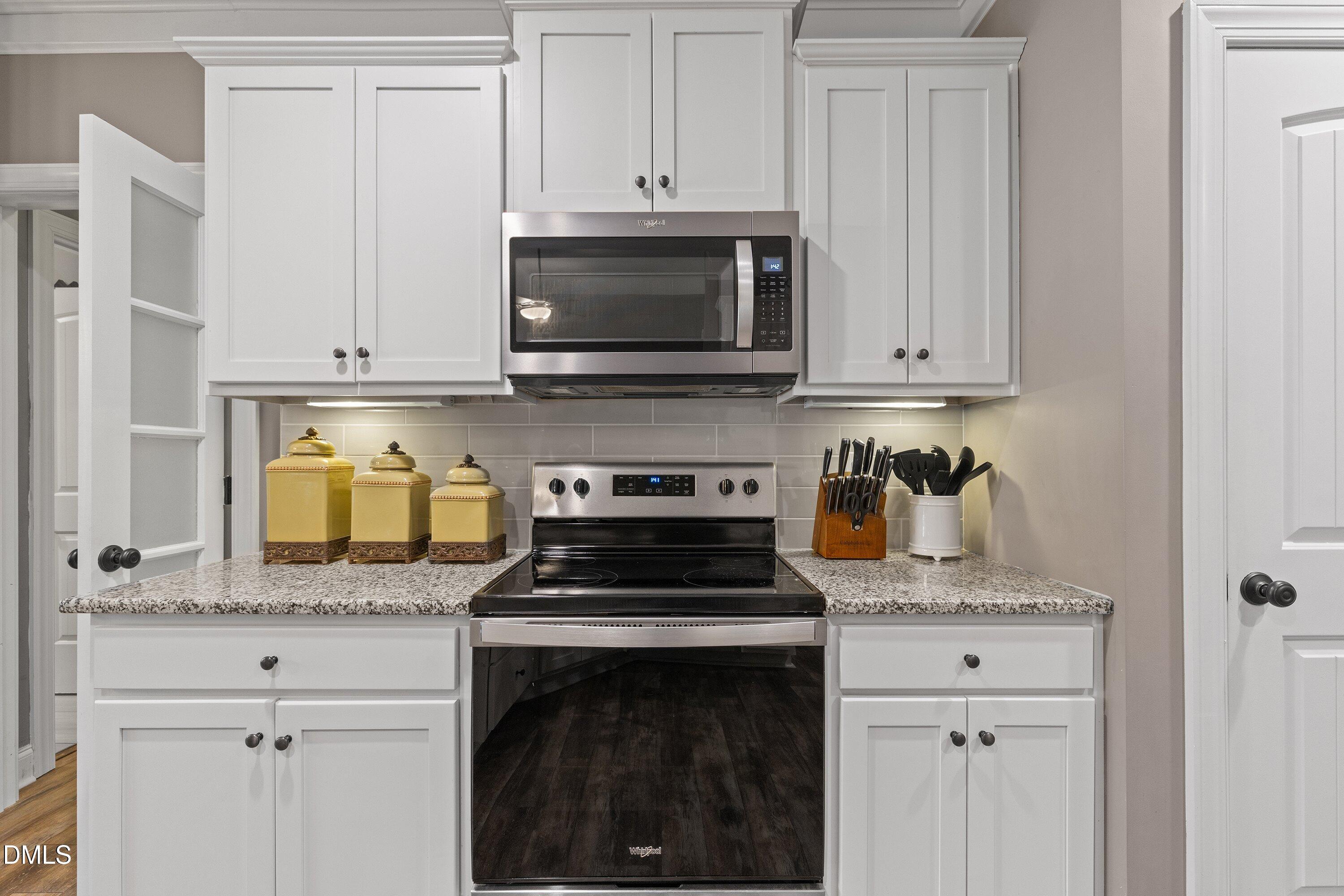 59 Coats Ridge Drive Benson, NC 27504 - Photo 10 of 44 a kitchen with granite countertop white cabinets and a stove a oven with white countertops