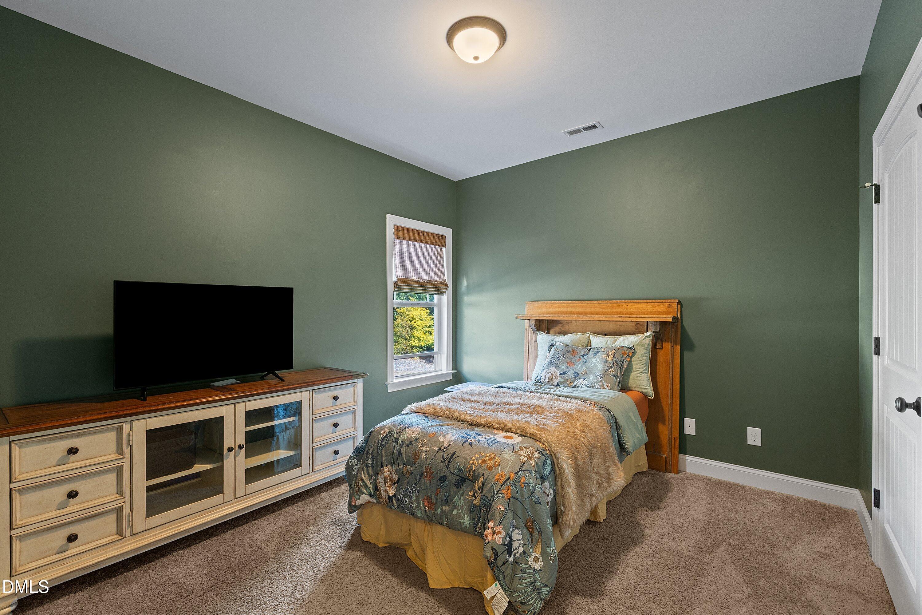 59 Coats Ridge Drive Benson, NC 27504 - Photo 24 of 44 a bedroom with a bed and a flat screen tv
