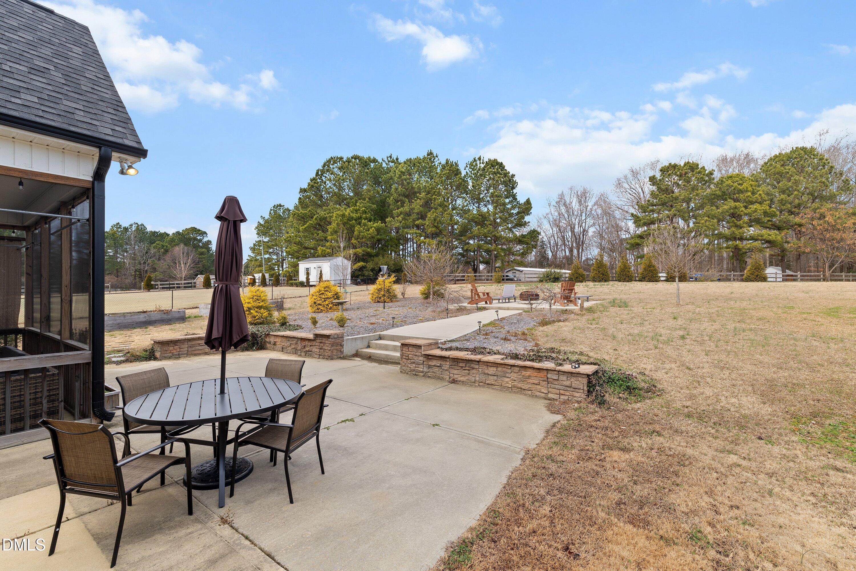 59 Coats Ridge Drive Benson, NC 27504 - Photo 36 of 44 a view of a patio with a table and chairs under an umbrella