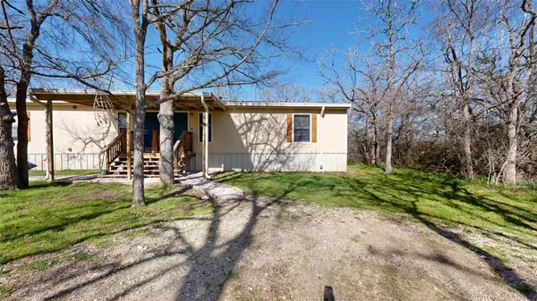 a view of a house with backyard and a tree
