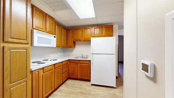a kitchen with stainless steel appliances granite countertop a refrigerator a stove and a sink with wooden floor