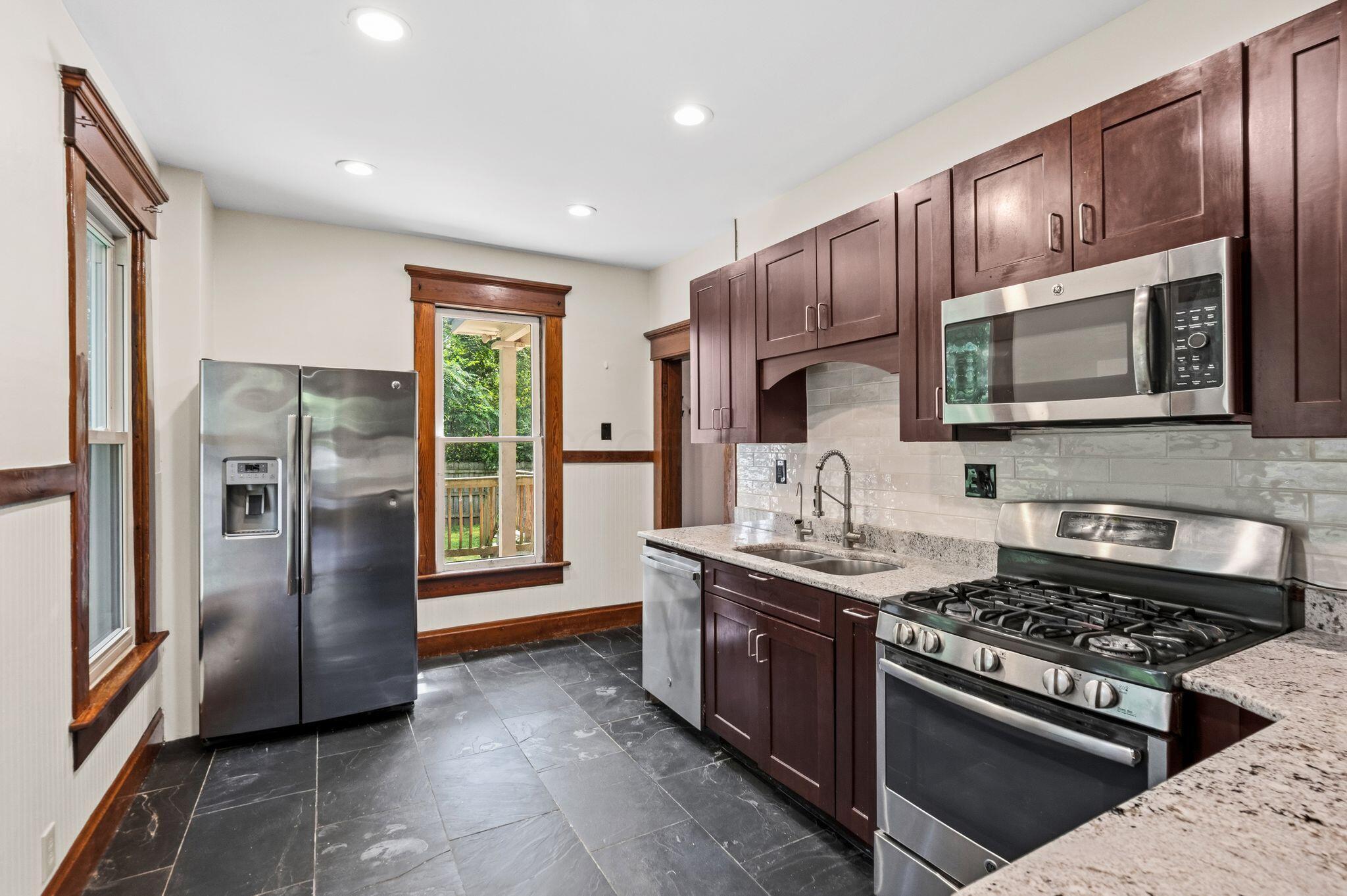 107 Price Road Columbus, OH 43230 - Photo 8 of 51 Kitchen featuring stainless steel appliances, dark wood cabinetry, and solid surface countertops