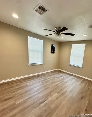 a view of a room with wooden floor and a ceiling fan
