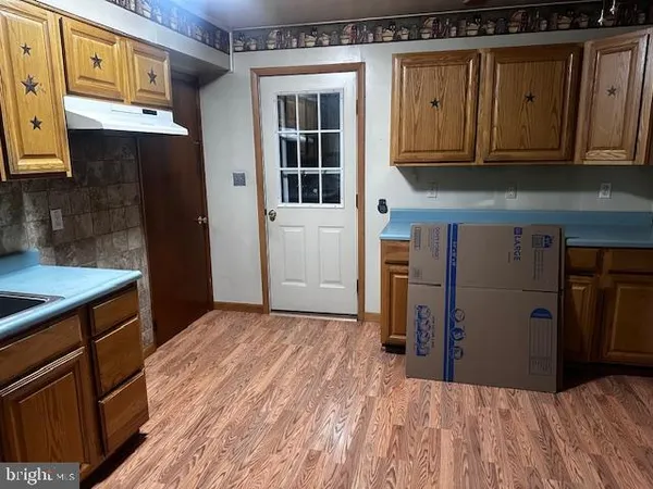 a kitchen with wooden floors and white cabinets