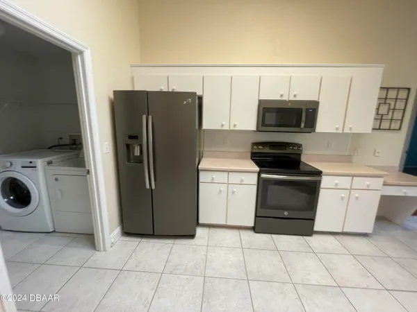 a kitchen with a refrigerator sink and cabinets
